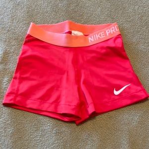 Nike Pro women’s shorts in red with peach waistband. Size small